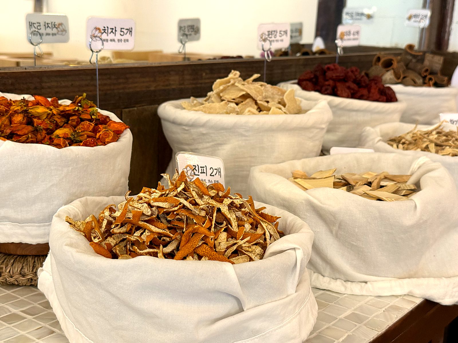치자와 진피가 담긴 소쿠리와 이름표 · Baskets of gardenia fruit and tangerine peel with their name tags