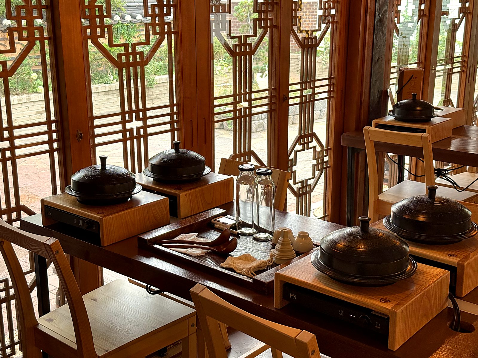 가마솥, 유리병, 재료 트레이가 놓인 체험 테이블 · A table set with an iron pot, a glass bottle, and an ingredient tray